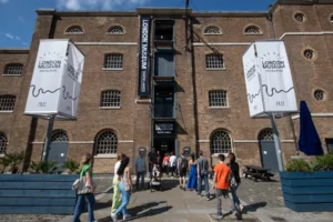 Exterior of London Museum Docklands. There are 4 levels of windows on a brown brick facade. 